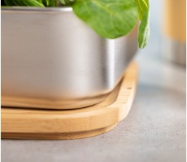 detalle de la fiambrera de acero inoxidable y tapa de bambú con ensalada en el interior