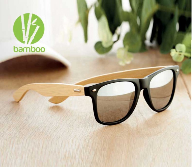 gafas de solo con varillas de bambu con lentes plateados encima de una mesa